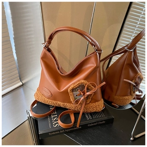 Detalle del bolso tote color caramelo con ribete de borreguito y lazo decorativo a cuadros
