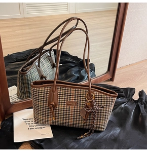 Detailaufnahme von Vintage Karostoff mit Lederbesatz und metallener Logo-Plakette