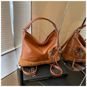 Detalle de bolso tote en cuero PU caramelo con ribete de piel de oveja sintética suave