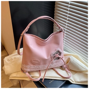 Detalle del bolso rosa de ecopiel con fondo de forro polar teddy y bonitos adornos de lazos