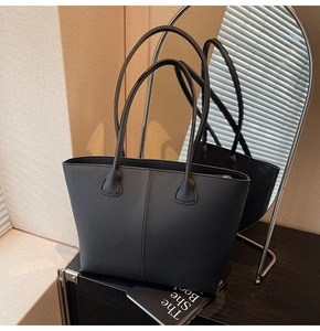 Close-up of black lychee texture leather tote bag with elegant stitching and zipper