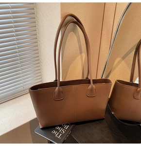 Detail of brown lychee leather tote bag with elegant vertical stitching for work