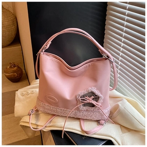 Detalle del bolso de hombro rosa en cuero sintético con ribete de felpa y lazo