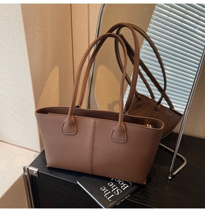 Detailed view of the brown lychee-textured tote bag showing trapezoidal side and stitching