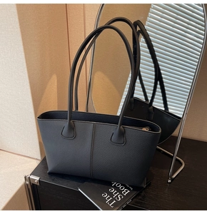 Detailed view of the black lychee texture leather tote bag with top zipper and stitching
