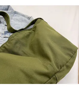 Detailansicht der olivgrünen Canvas-Tasche mit breitem Schultergurt im Retro-Stil