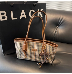 Detailansicht der Vintage-Tasche mit Hahnentrittmuster, Ledergriff und gewebtem Anhänger