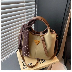 Détail du sac seau rétro avec poignée en foulard à pois et emblème métallique élégant