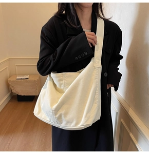 Minimalistische beige Segeltuch-Hobo-Tasche mit breitem Schultergurt in moderner Inneneinrichtung