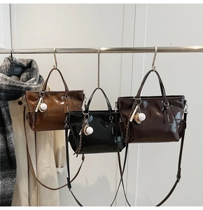 Detailed view of large tote bags in brown, black, and coffee with baseball charms
