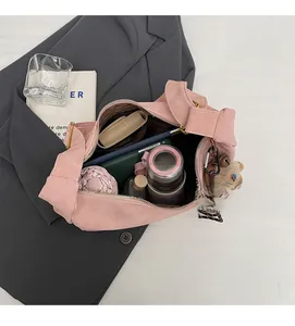 Top view of open pink suede bag interior showing storage for umbrella and bottle