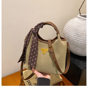 Détail d'un sac seau vintage beige avec garniture en cuir marron et foulard à pois décoratif