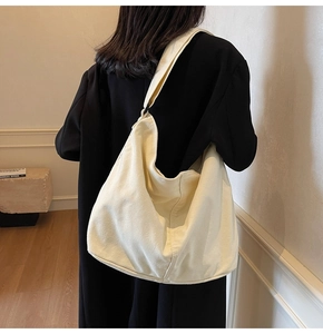 Minimalistische beige Segeltuch-Beuteltasche an der Schulter in stilvollem Interieur