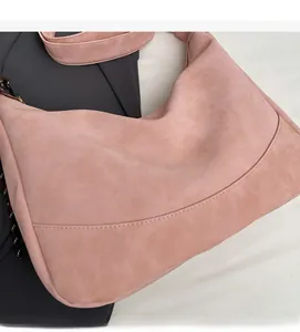 Close-up of pink suede hobo bag showing soft texture and reinforced stitching details