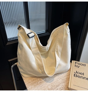 Detail der minimalistischen Canvas-Hobo-Tasche mit verstellbarem Riemen auf Steinfläche