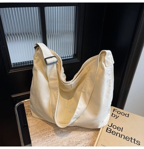 Detailierte Textur der cremeweißen Canvas Hobo-Tasche mit schwarzer Einstellschnalle
