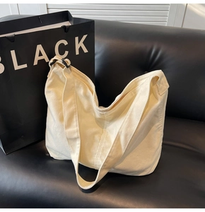 Detailansicht der Canvas-Tasche mit breitem Gurt und schwarzer Schnalle auf Sofa