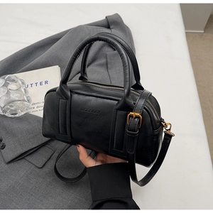 Close-up of black lychee grain leather boston bag with embossed logo and bronze hardware