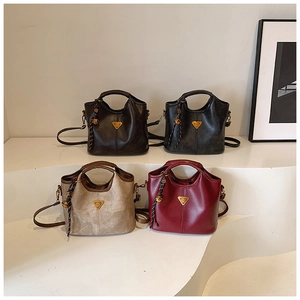 Détail de quatre sacs seaux en cuir PU de différentes couleurs avec ornements en métal