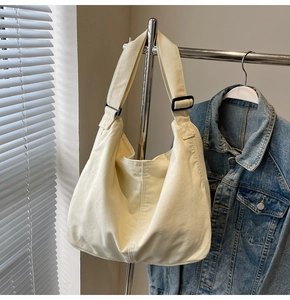 Detail einer beigen Segeltuchtasche mit verstellbarem Riemen und grober Stoffstruktur