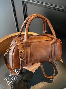 Vintage brown leather Boston bag with embossed logo and adjustable shoulder strap