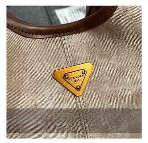Gros plan sur le tissu sergé kaki et la plaque métallique vintage d'un sac seau