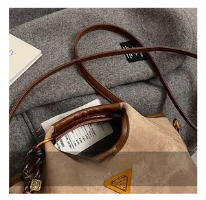 Détail du sac seau marron texturé avec poignée circulaire et logo en métal
