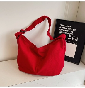 Detail einer großen roten Canvas-Damentasche in minimalistischem Design mit verstellbarem Gurt