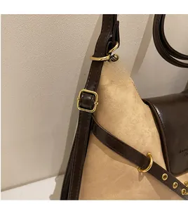 Detail view of the adjustable brown leather strap and gold hardware on a canvas tote