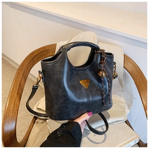 Détail du sac cabas rétro gris foncé avec logo doré et décoration en corde tressée