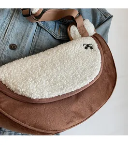 Detail of the plush lamb wool crossbody bag with a black metal bow and zipper closure
