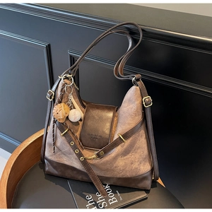 Close-up of vintage canvas tote with leather trim and decorative baseball charm