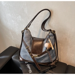 Detail of vintage canvas tote with leather trim and sports-themed decorative charms