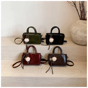 Détail de mini sacs à main en similicuir en quatre couleurs avec breloques peluche
