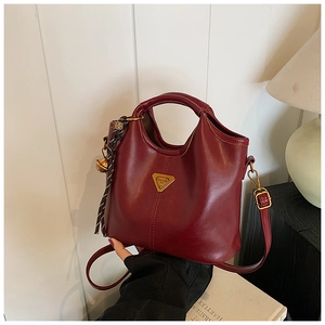 Vue détaillée d'un sac cabas bordeaux en similicuir avec logo et ruban rayé