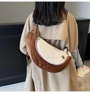 Detail of plush crescent crossbody bag in brown suede and cream faux fur on a model