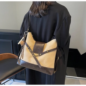 Rear view of model wearing retro two-tone tote bag with beige canvas and brown leather details