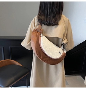 Brown suede and white fleece crescent crossbody bag shown on a person back