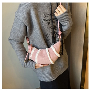 Detail der rosa Croissant-Tasche mit weißen Plüschstreifen und weicher Wildlederstruktur