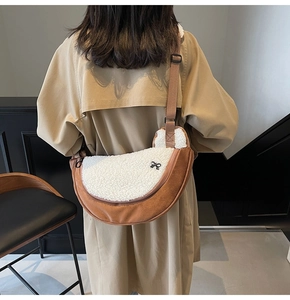 Detail of plush faux shearling dumpling bag with suede patchwork and bow accent