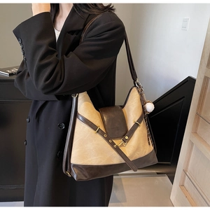 Detail of retro two-tone tote bag featuring contrast stitching and white spherical charm
