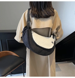 Close-up of black and white fuzzy sherpa crossbody bag on a khaki trench coat