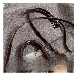 Détails d'un sac à main rétro en cuir ciré avec poignée renforcée et pompon doux
