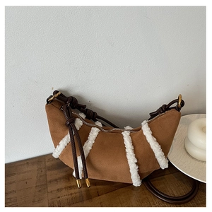 Detailansicht der Halbmondtasche aus braunem Wildleder mit Plüschbesatz und goldener Hardware