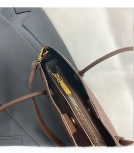 Détail du sac cabas en cuir marron foncé avec fermeture éclair dorée et doublure interne