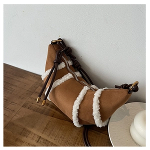 Nahaufnahme der braunen Wildledertasche mit weißem Lammfellbesatz und Knotengurt
