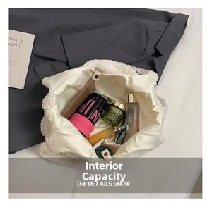 Dettaglio interno della capiente borsa in pelliccia sintetica bianca con bottone a pressione