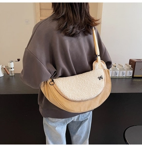 Close-up of the plush crescent bag showing soft faux fur texture and contrast stitching