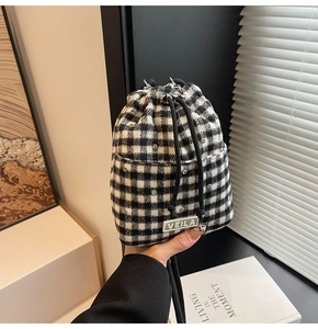 Λεπτομέρεια τσάντας tweed με ασπρόμαυρο καρό σχέδιο και διακόσμηση με στρας