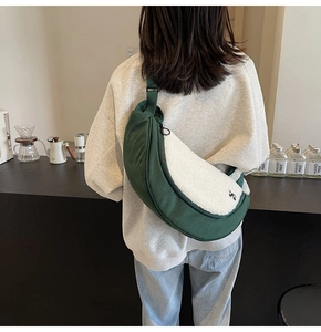Detail view of the green and white fuzzy half-moon crossbody bag shown on a model